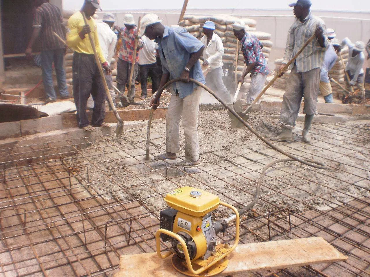 Une équipe réalise le coulage du béton sur une dalle ferraillée. Photographie de chantier fournie par OLAMIDE.