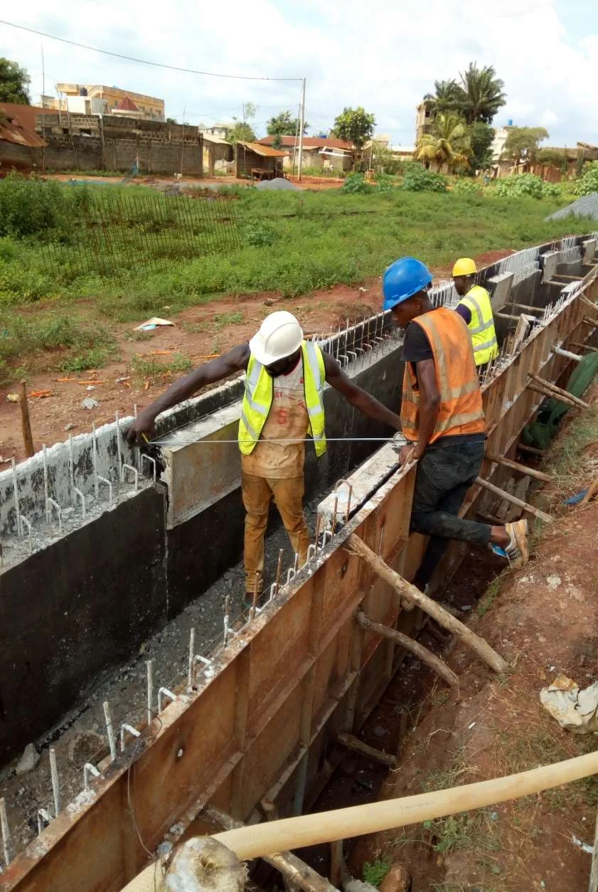 Des ouvriers interviennent sur le coffrage d’un caniveau en béton armé. Photographie fournie par OLAMIDE.